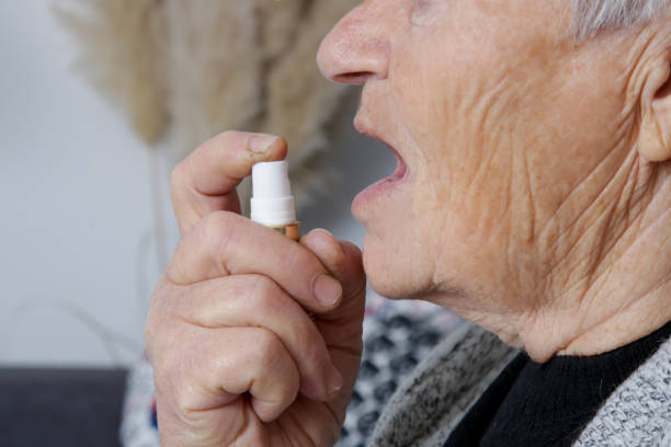 An older adult using a sublingual oral spray